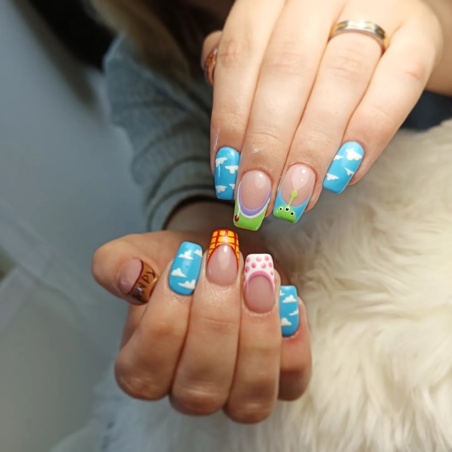 Lange nagels met blauwe lucht, wolkjes en Toy Story-figuren